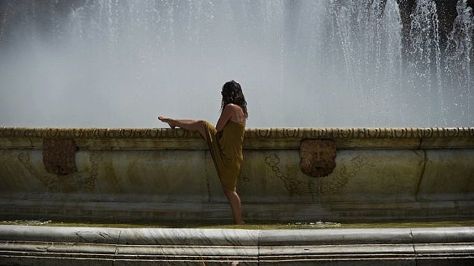 Женщина охлаждается в фонтане в Севилье. Фото: AFP